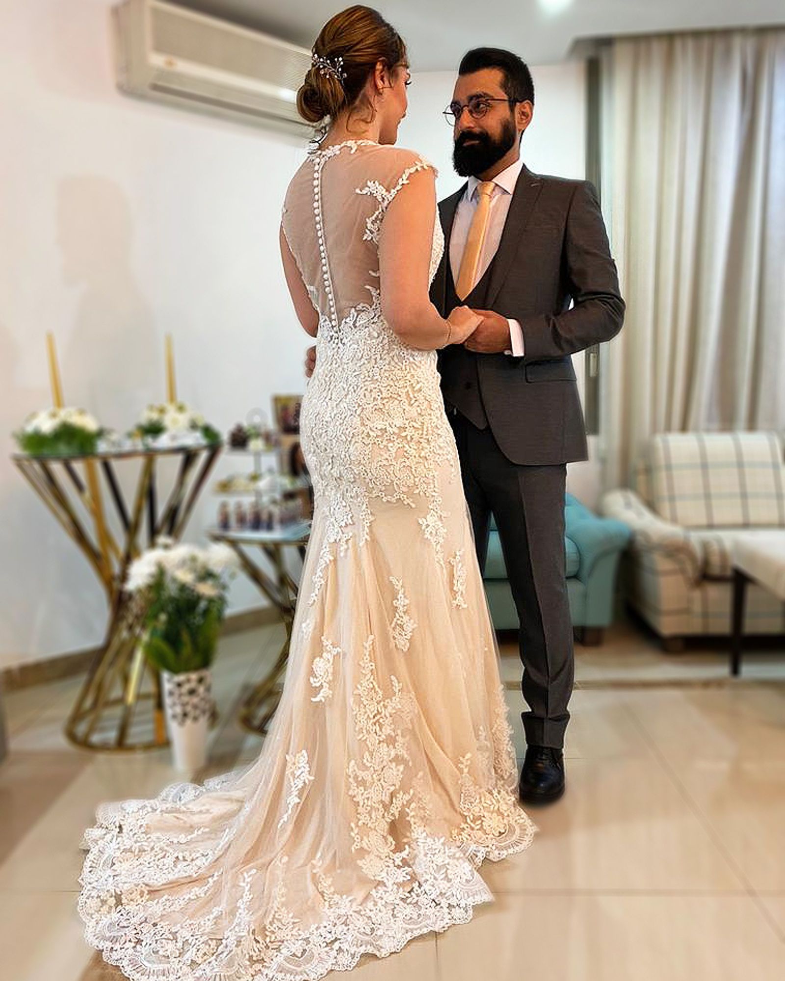Bride in a lace gown with a chapel train and illusion button back, altered by Nina in Sandy Springs, Georgia